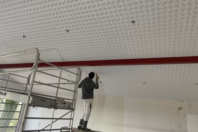 Ouvrier qui pose du placo au plafond